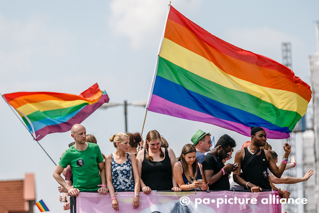 Teilnehmer posieren unter Regenbogenfahnen auf einem Musik-Truck am 02.08.2014 in Hamburg auf dem Christopher Street Day (CSD).
