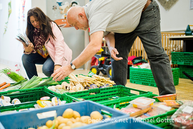 Elisabeth Lorscheid und Helmut Brügelmann bereiten Lebensmittel fuer die Abholung durch Bedürftige vor, in den Raeumen des Kalker Kindermittagstisch e.V.