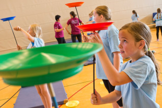 Kinder balancieren Teller beim Ferienprojekt des Sportverein TV Arnsberg.