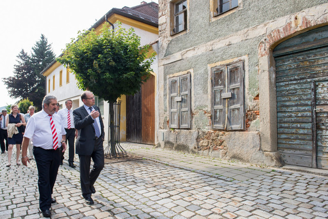 Beim Ortsrundgang vor dem Bürgerdialog Gut leben auf dem Land in Rötz in informiert Bürgermeister Ludwig Reger Bundesminister Christian Schmidt über die Leerstandsproblematik in seiner kleinen Stadt in der Oberpfalz.